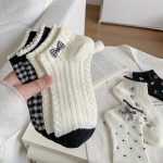 White crew socks with embroidered bunny and checkered bow detail styled with black sneakers.