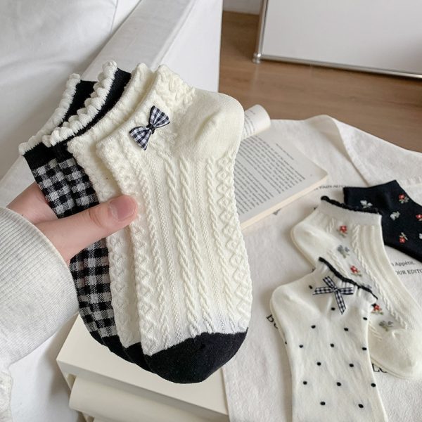 White crew socks with embroidered bunny and checkered bow detail styled with black sneakers.