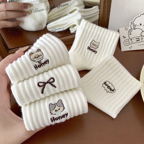 White ribbed crew socks with cute cat and bow embroidery and honey text detail.
