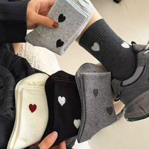 A close-up of grey Heartstrings ribbed crew socks styled with dark grey athletic sneakers.