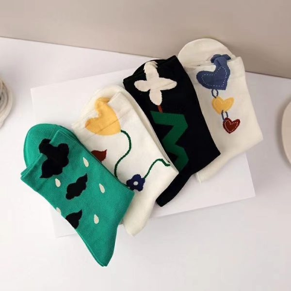 A folded 4-pair bundle of our Whimsical Crew Sock Set showing the cartoon heart, floral, and cloud designs.