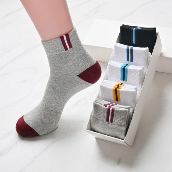 A stylish display of men's in-tube crew socks, with one grey sock being modeled and others neatly packed in a gift box.
